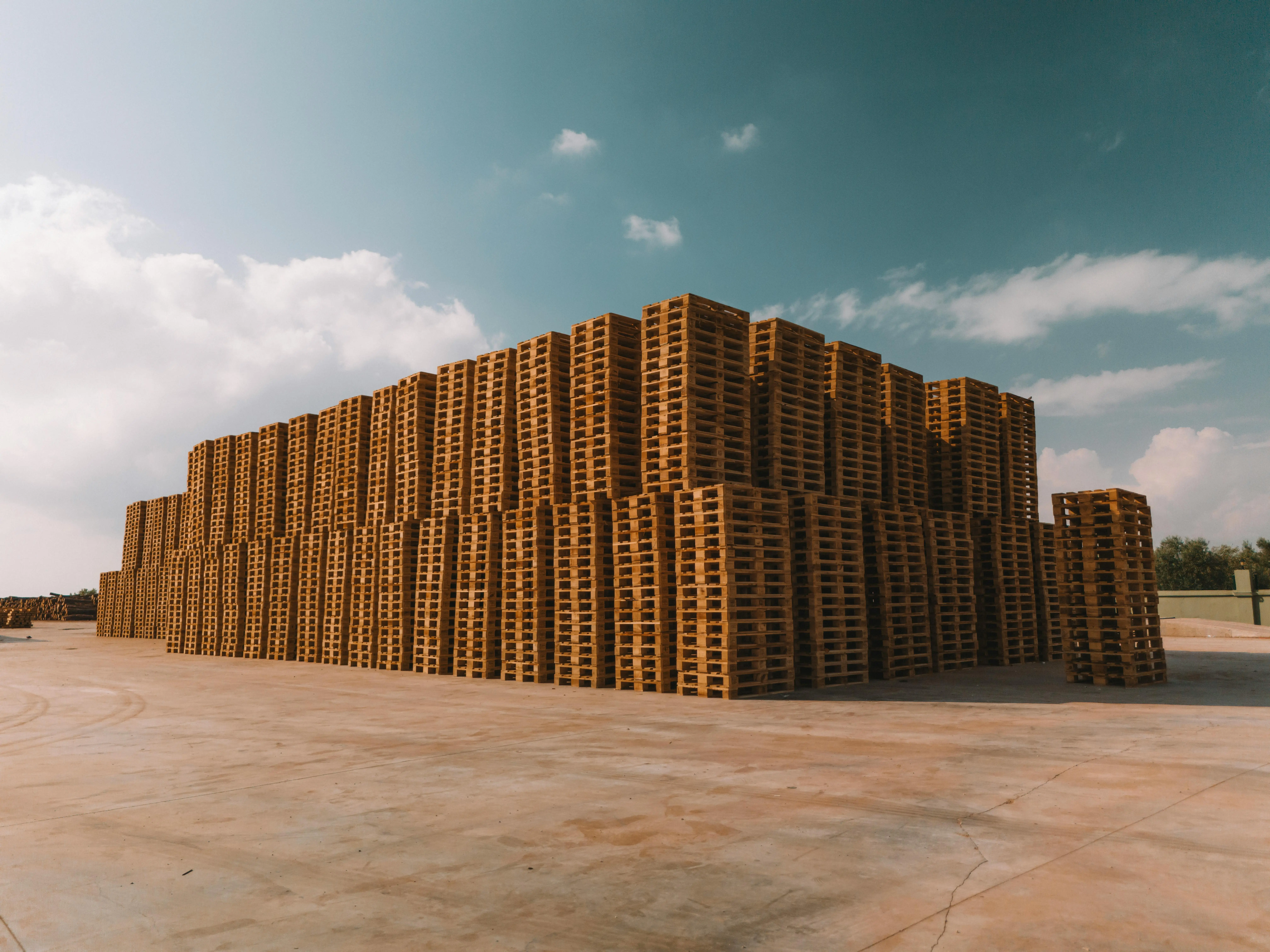 Stacked Wooden Pallets Under Blue Sky